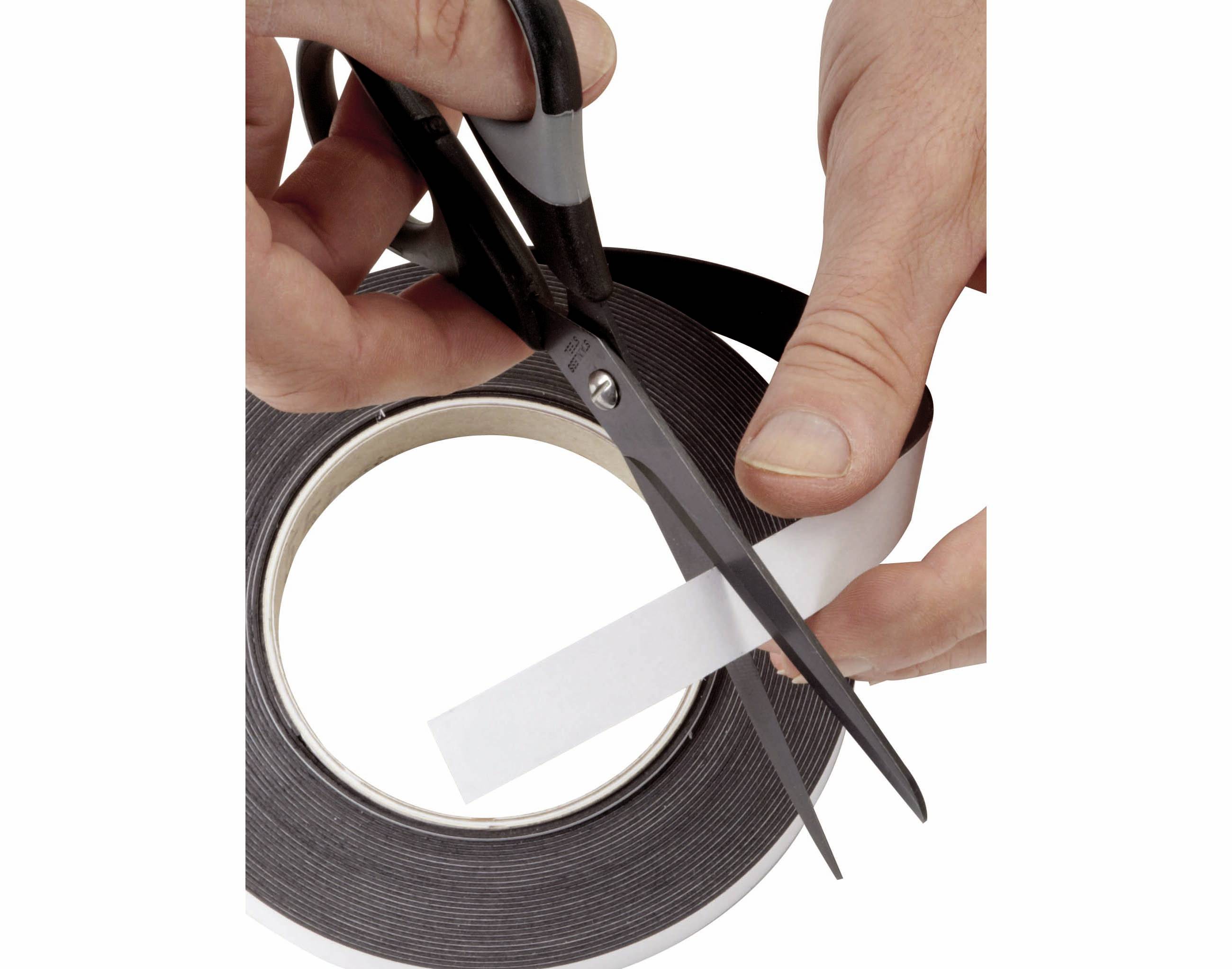 Eine Hand hält eine Schere und schneidet ein Stück von einem Klebeband in schwarzer Rolle ab.