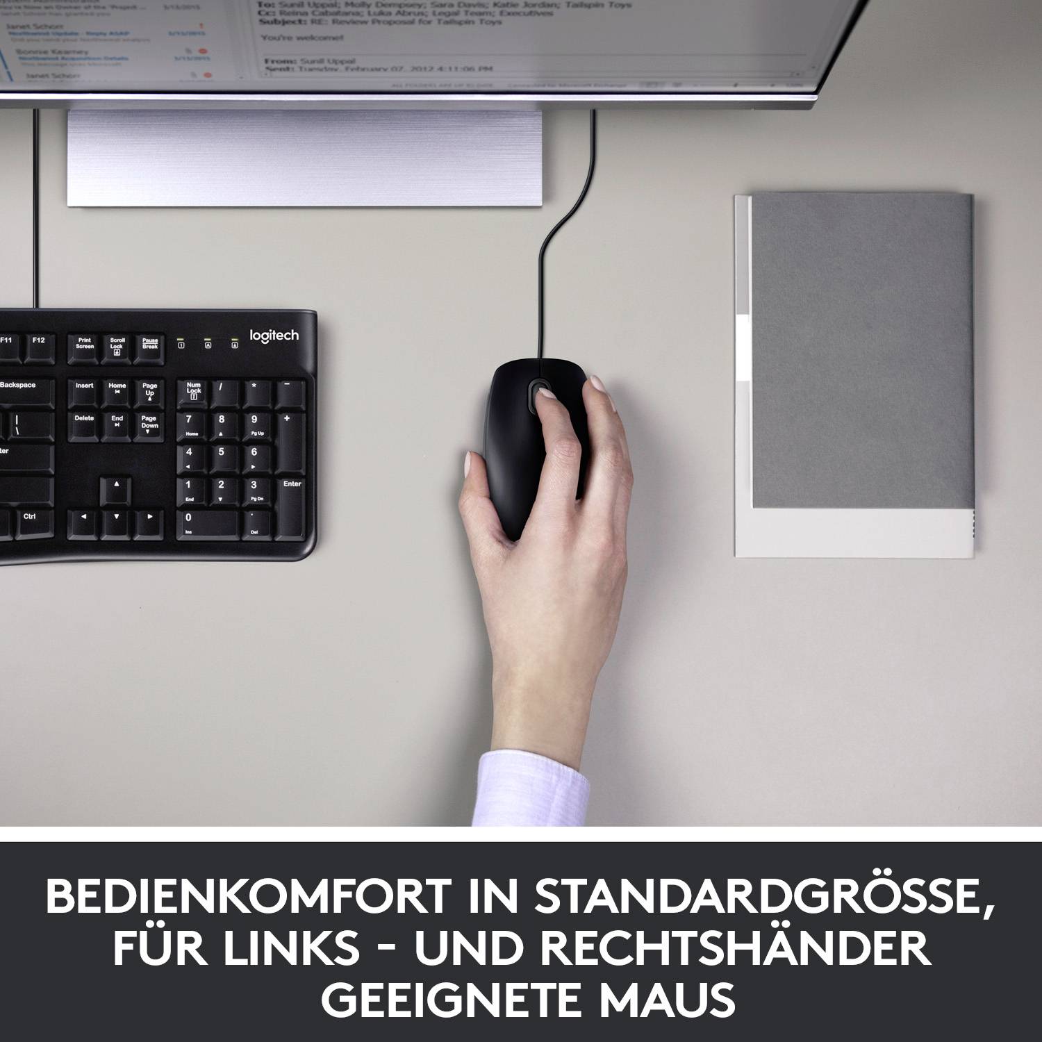 Hand benutzt Maus auf einem Schreibtisch neben einer Tastatur. Bildschirm zeigt ein Menü. Darunter Text: 'Bedienkomfort in Standardgröße'.