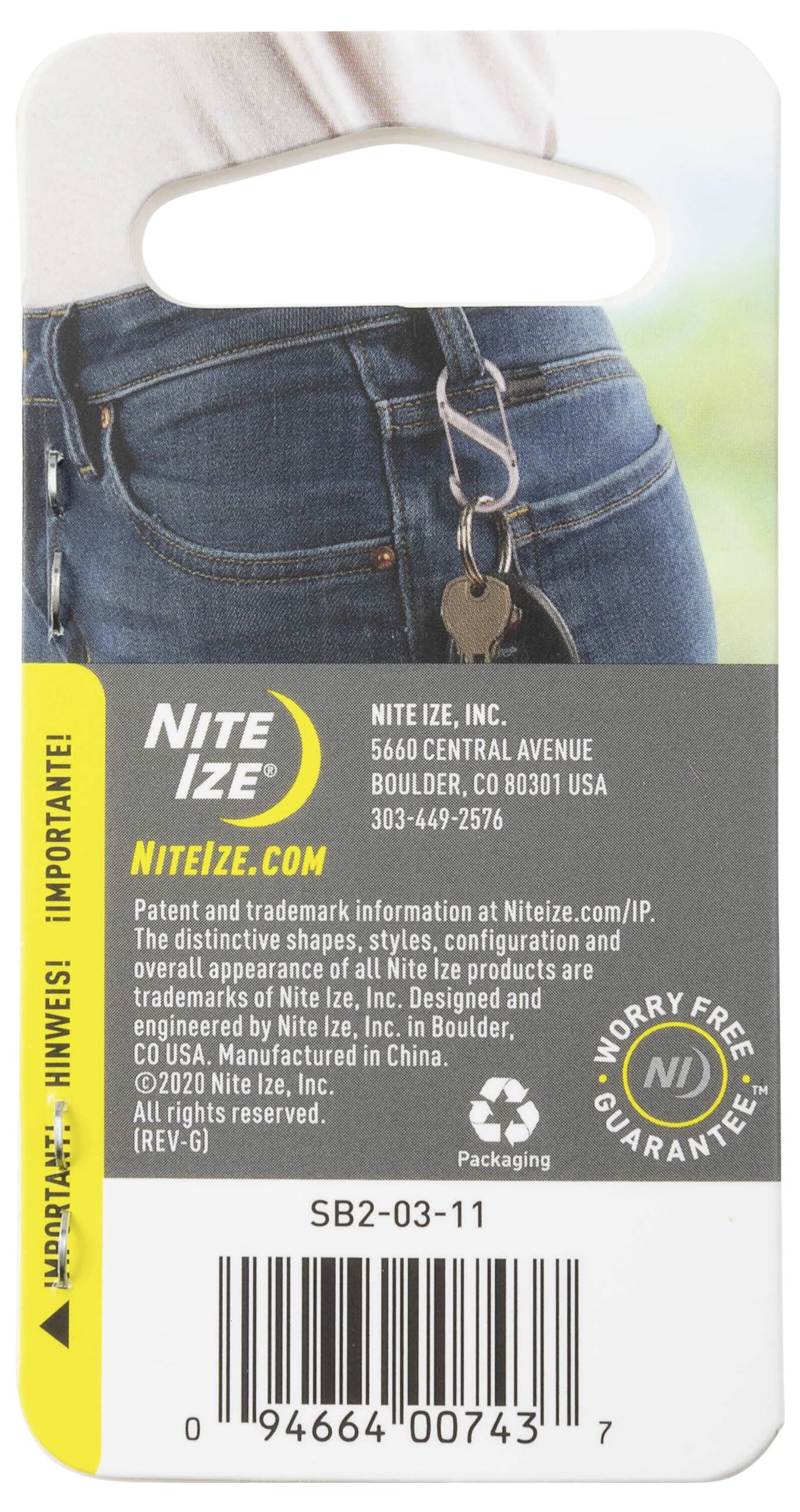 Eine Person trägt Jeans mit an einer Klemme befestigten Schlüsseln. Der Text liest sich "Nite Ize" und enthält Unternehmensinformationen: Boulder, CO, USA.