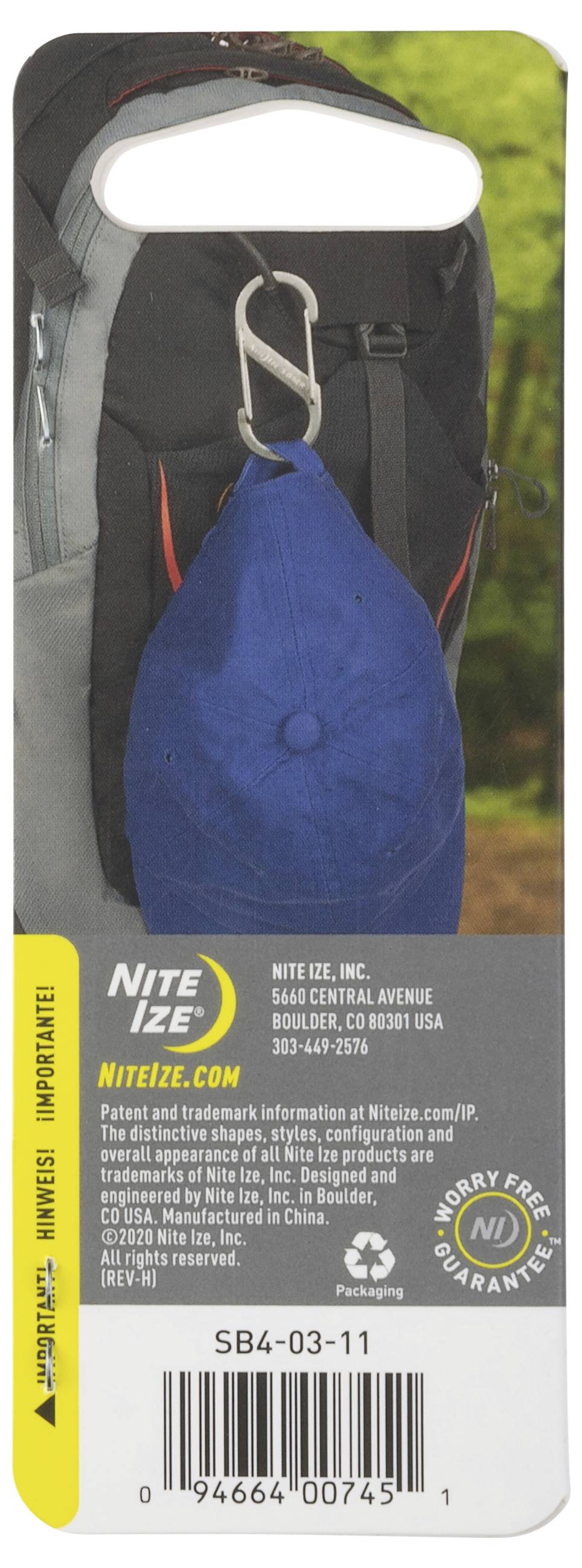 Ein Anhänger an einem Rucksack mit einem blauen Gegenstand, der mittels eines Clips befestigt ist. 'Nite Ize' Logo und Kontaktinformationen sind darunter angezeigt.