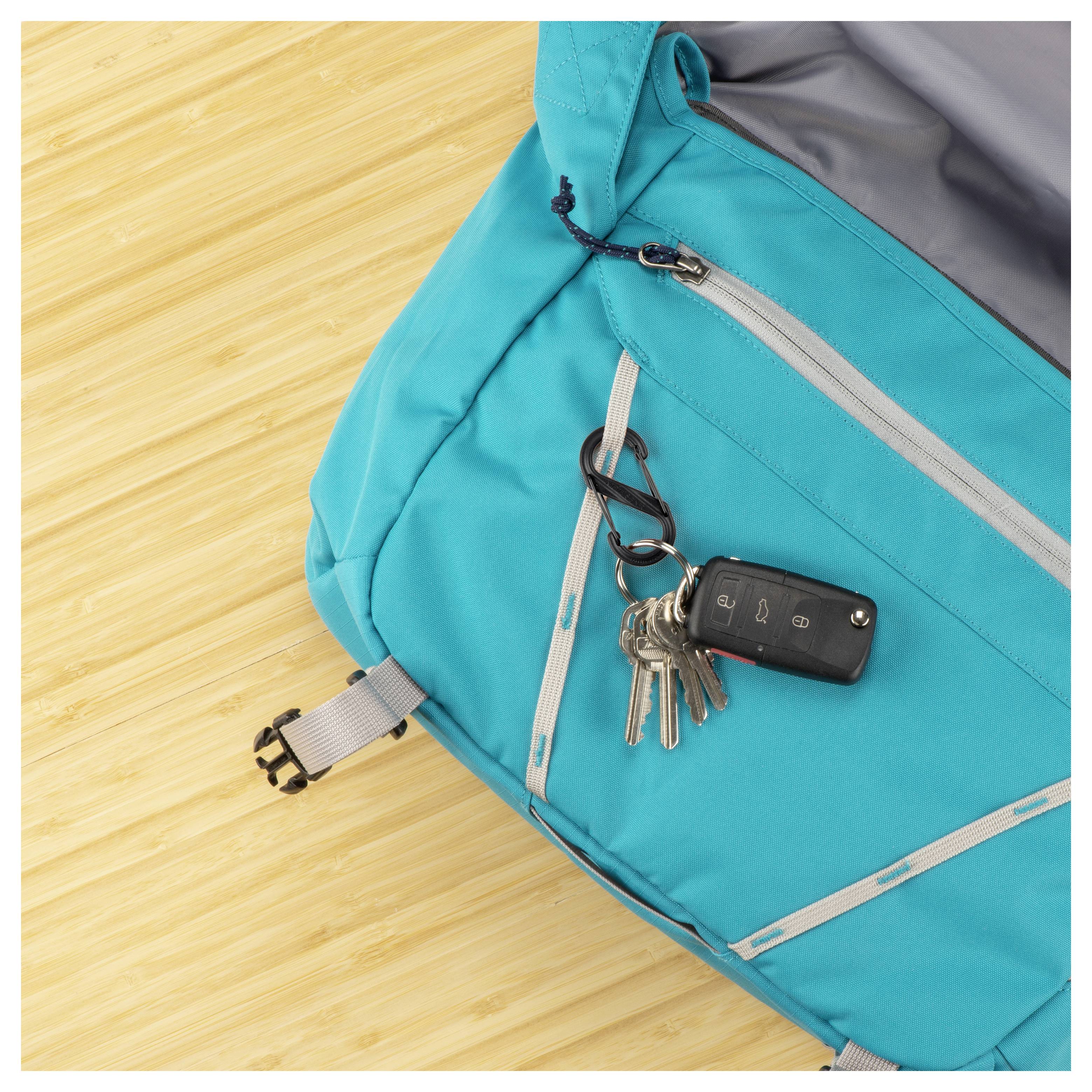 Blauer Rucksack auf einer Holzoberfläche mit an einem Reißverschluss befestigten Schlüsseln.