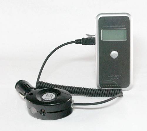 Ein Alkoholtester mit Mundstück und digitalem Display zur Messung des Atemalkoholgehalts, verbunden durch ein Spiralkabel.