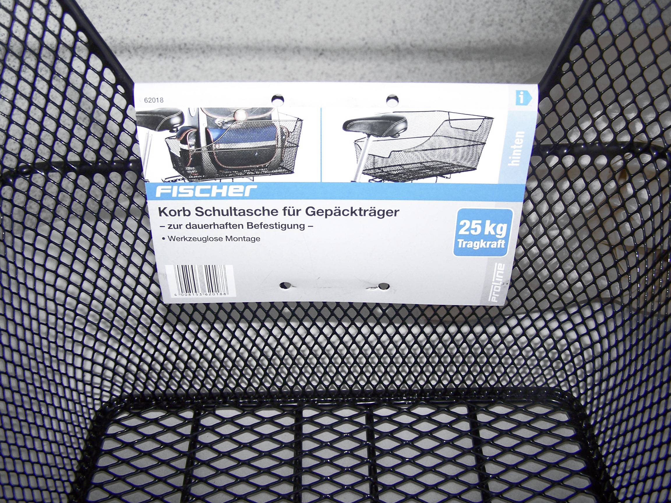 Ein schwarzer Drahtkorb mit einem Etikett. Auf dem Etikett steht 'Korb Schultasche für Gepäckträger', mit einer Tragkraft von 25 kg.