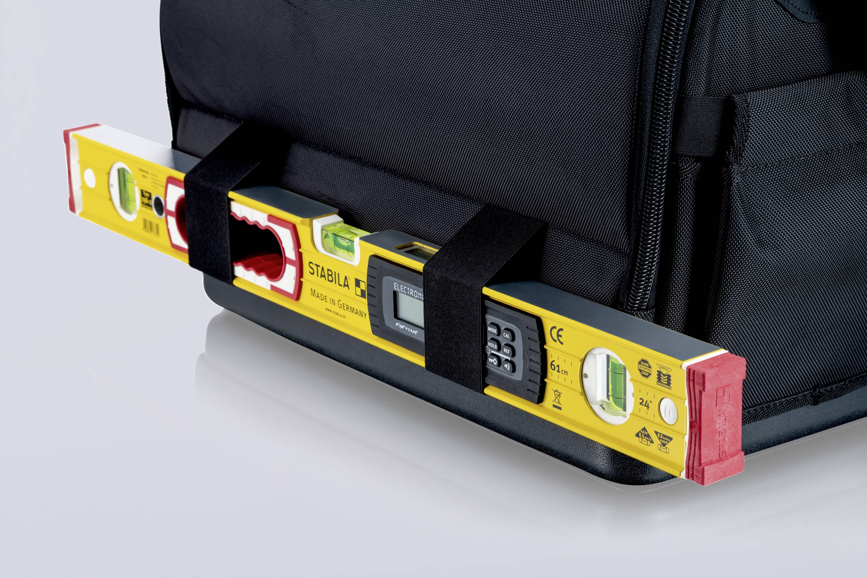 'Wasserwaage mit digitalen Anzeigen in Halterungen an einer Werkzeugtasche befestigt.'