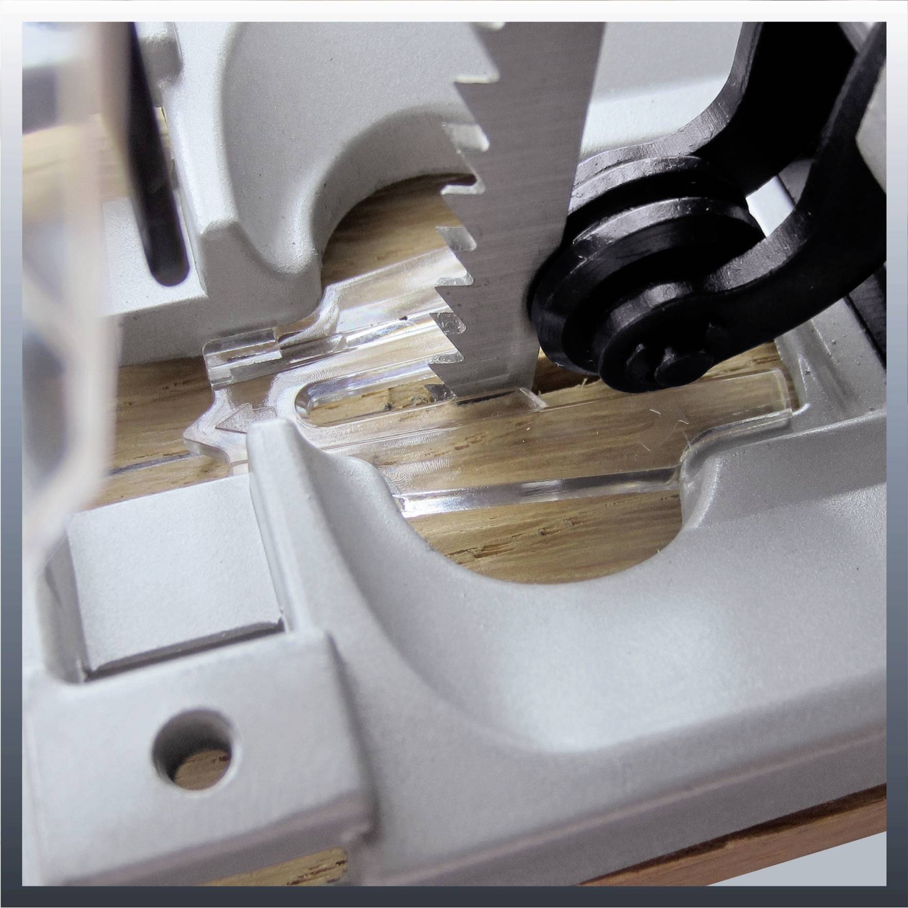 Nahaufnahme eines Stichsägeblatts, das durch ein Stück Holz schneidet. Zu sehen sind das Sägeblatt und das Holz in einer Halterung.