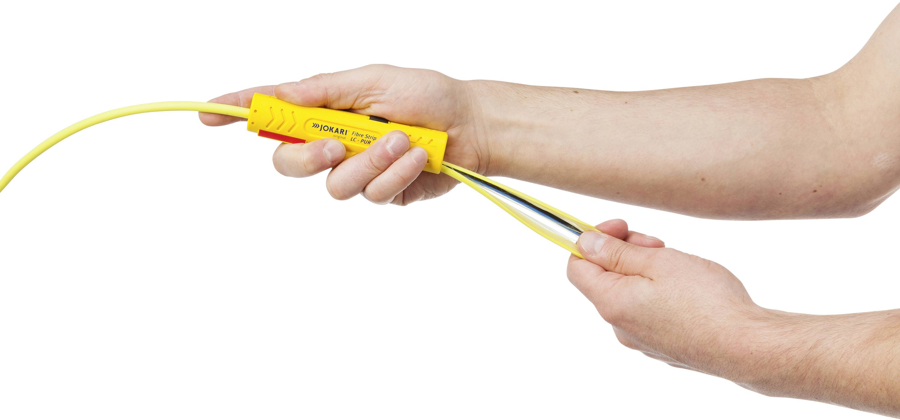 'Hände halten ein Spannungsprüfergerät, das an ein gelbes Kabel angeschlossen ist.'