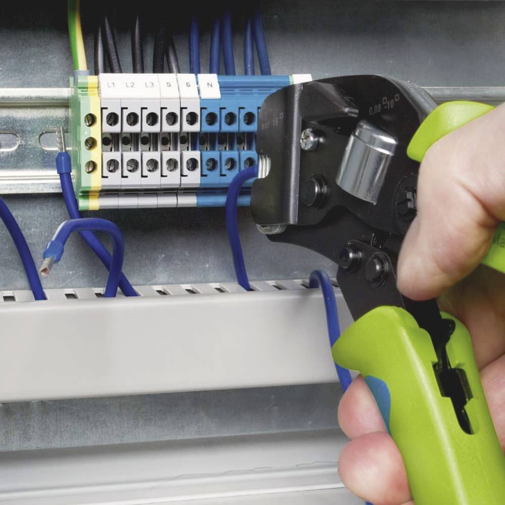 Eine Person verwendet eine Crimpzange, um Drähte in einem elektrischen Anschlusskasten zu befestigen.