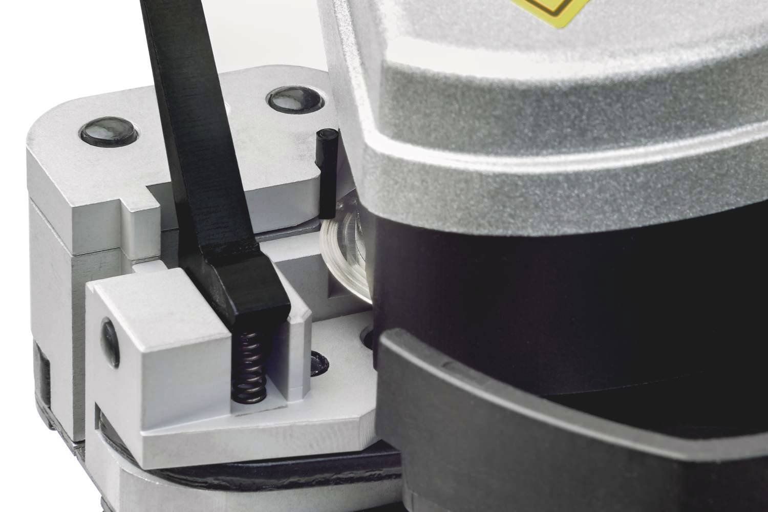 Ein silbernes Gerät mit mechanischen Teilen und Hebel, vermutlich ein Schneid- oder Presswerkzeug, wird im Close-up gezeigt.