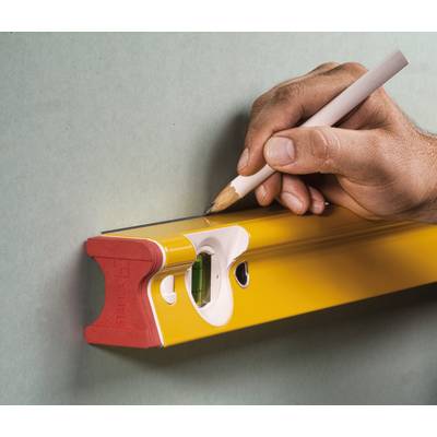 Eine Hand hält einen Bleistift und zeichnet eine Linie entlang einer gelben Wasserwaage an einer Wand.