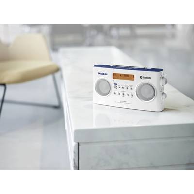 Ein tragbares Radio mit Bluetooth-Funktion steht auf einem hellen Marmortisch in einem modern eingerichteten Raum.