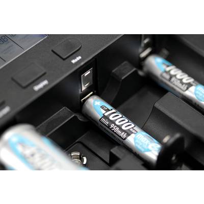 Nahaufnahme eines Batterieladegeräts mit eingelegten AA-Akkus, die aufgeladen werden. Der Ladezustand wird über ein Display angezeigt.