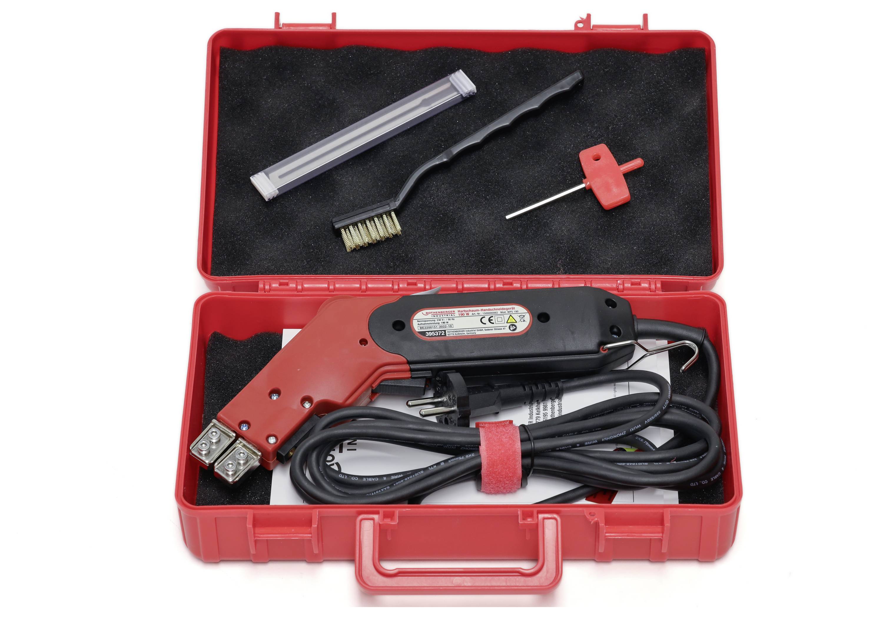 Ein roter Koffer mit einem elektrischen Schneidgerät, Bürste, Reinigungswerkzeug und Netzkabel. Perfekt für präzises Arbeiten.