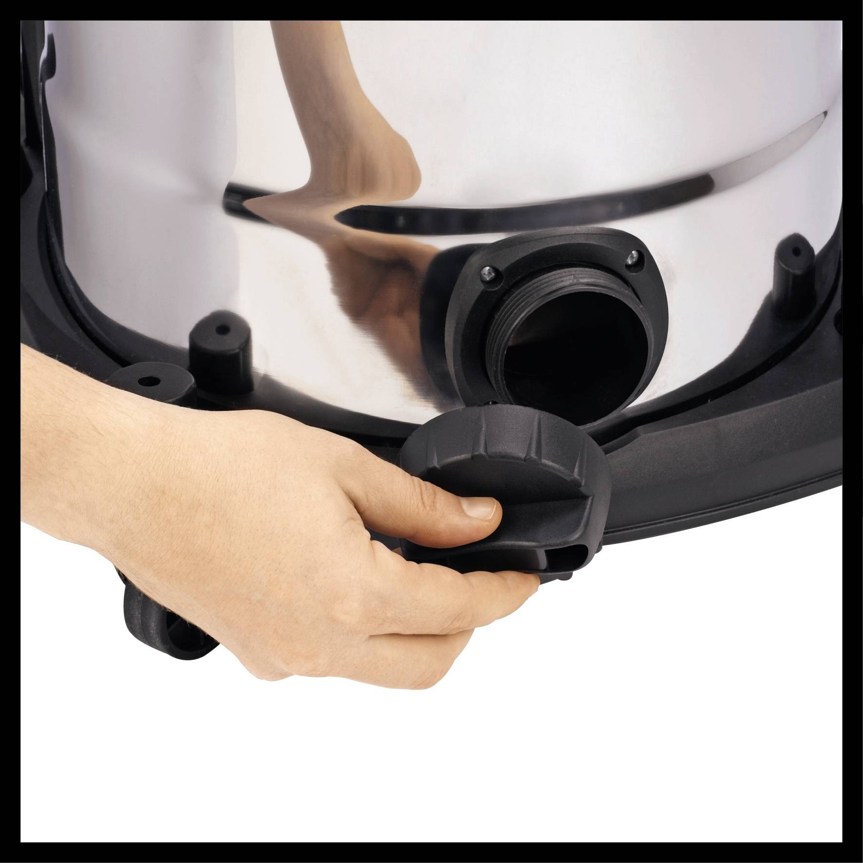 Eine Hand dreht den Verschluss eines silbernen Geräts, möglicherweise ein Staubsauger oder ein anderes Haushaltsgerät.