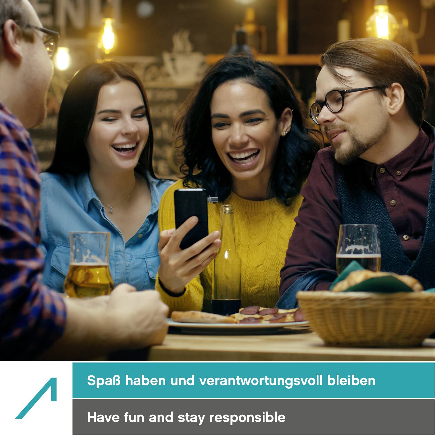 Eine Gruppe von vier Personen sitzt an einem Tisch in einer Bar, lacht und schaut auf ein Smartphone-Bildschirm. Darunter der Text: 'Spaß haben und verantwortungsvoll bleiben'.