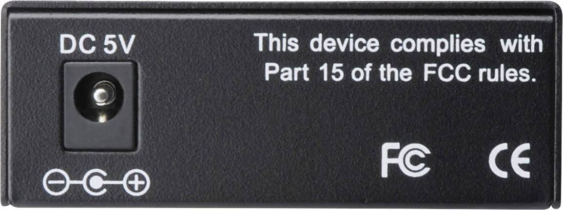 Schwarzes Netzteil mit Aufschrift 'DC 5V'. Text: 'This device complies with Part 15 of the FCC rules'. Symbole: FCC, CE.