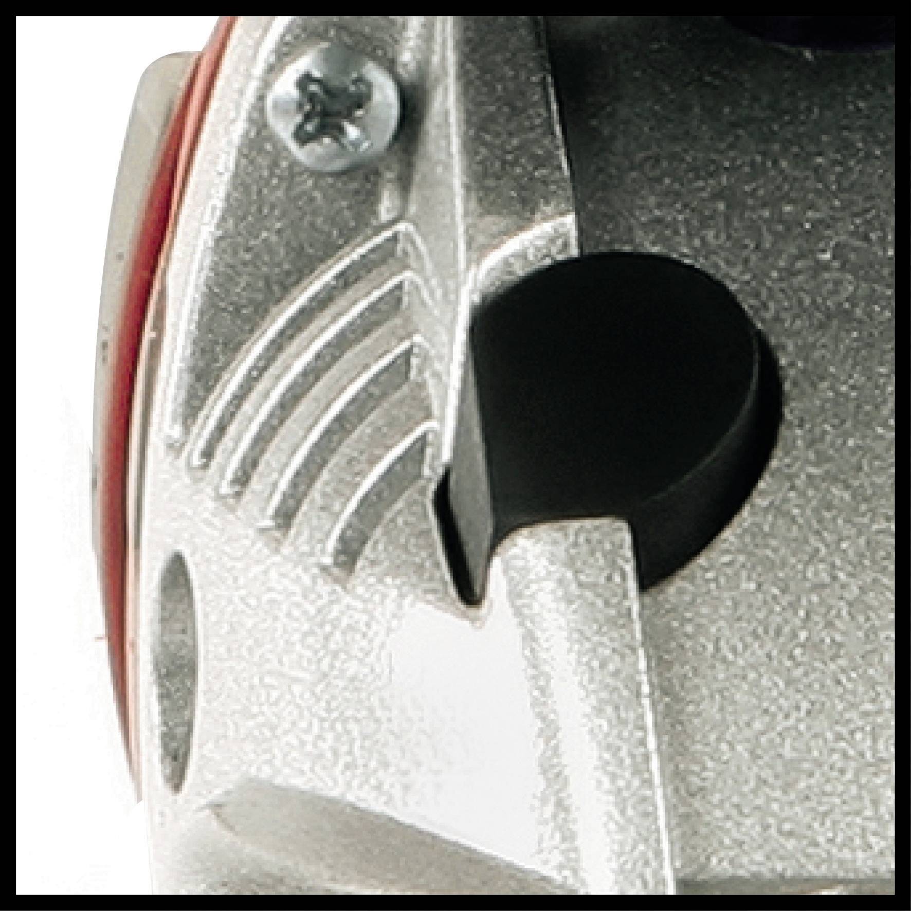 Nahaufnahme eines Metallgeräts mit strukturierten Linien und einer dunklen, runden Öffnung, möglicherweise Teil einer Maschine.