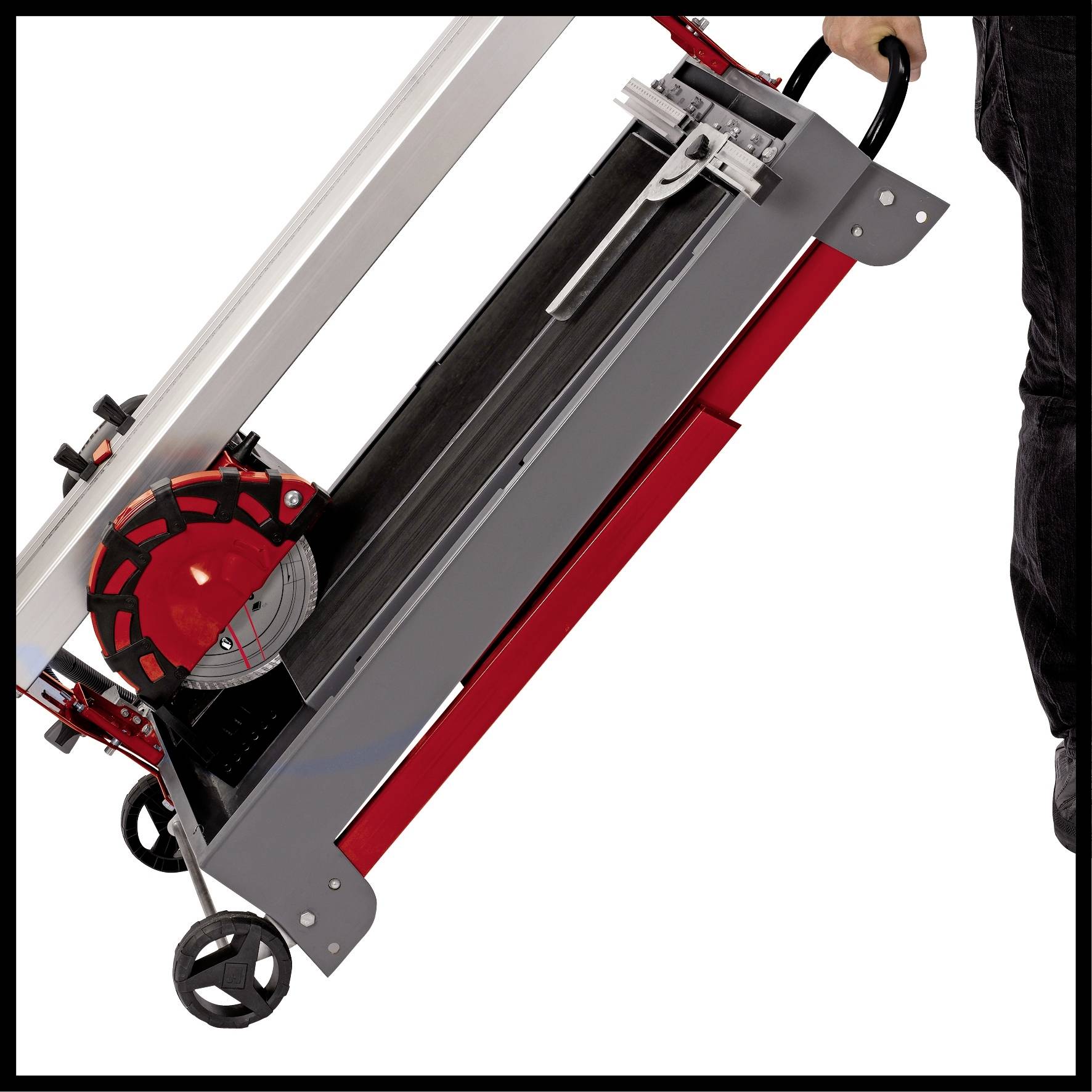 'Tischkreissäge wird von einer Person auf zwei Rädern transportiert, zeigt Tragbarkeit und Mobilität des Werkzeugs im Einsatz.'