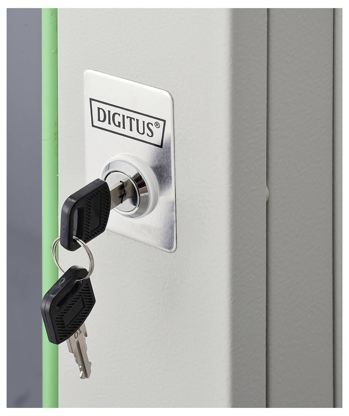 Eine Nahaufnahme eines Metallschrankverschlusses mit zwei eingesteckten Schlüsseln, beschriftet mit ‚DIGITUS'. Der Schrank ist grau mit einem teilweise sichtbaren grünen Rand.