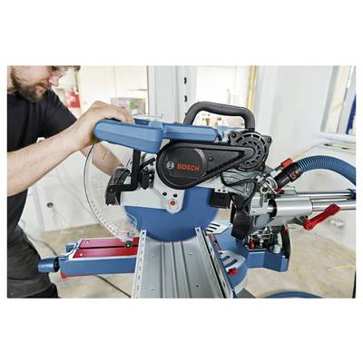 Ein Mann stellt eine Bosch-Gehrungssäge auf einer Werkbank ein und bereitet sich darauf vor, Material in einer Werkstatt zu schneiden.