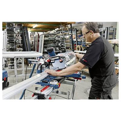 Hände, die einen Bosch-Fräser verwenden, der in einem Oberfräsentisch montiert ist, für Holzbearbeitung auf einer Holzwerkbank.