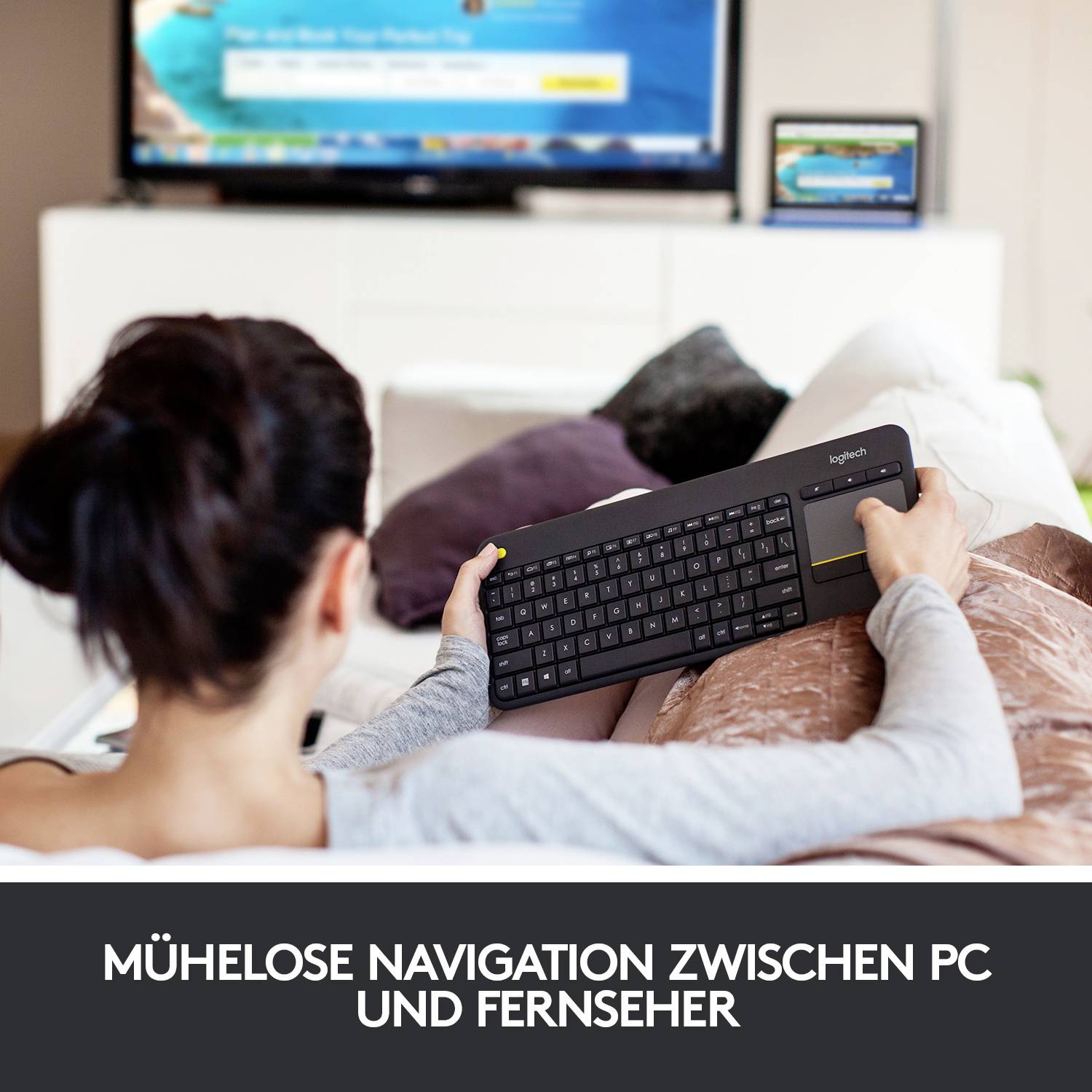 Person entspannt auf dem Sofa, nutzt eine drahtlose Tastatur, um den Fernseher zu steuern. Text am Bildrand: 'Mühelose Navigation zwischen PC und Fernseher'.