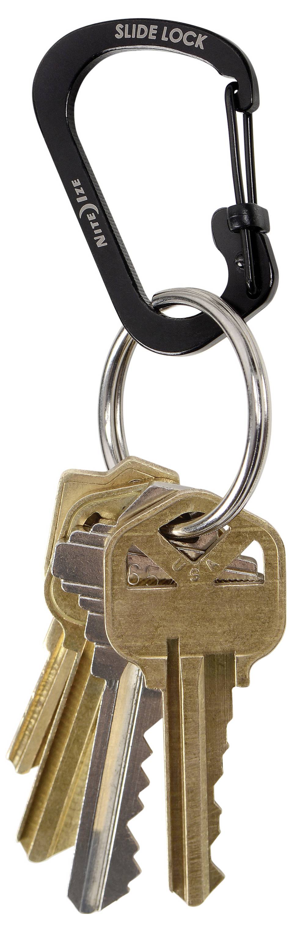 Ein schwarzer Karabiner mit der Aufschrift "Slide Lock" hält einen Ring aus Messingschlüsseln.