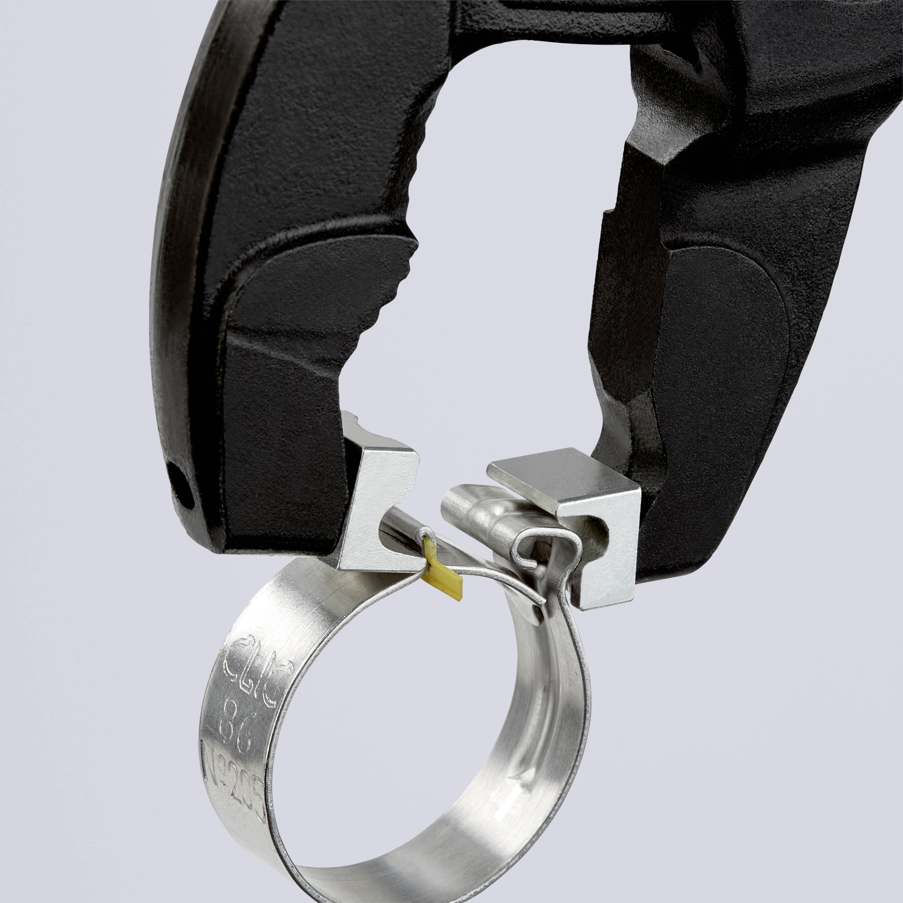 Ein schwarzer L-förmiger Pistolenhalter wird an einem silbernen Metallspanner befestigt.