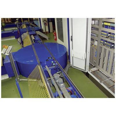 Eine blaue, runde Fabrikmaschine mit Förderbändern und Steuerpanel, umgeben von Regalen mit elektrischen Komponenten in einer Industriehalle.