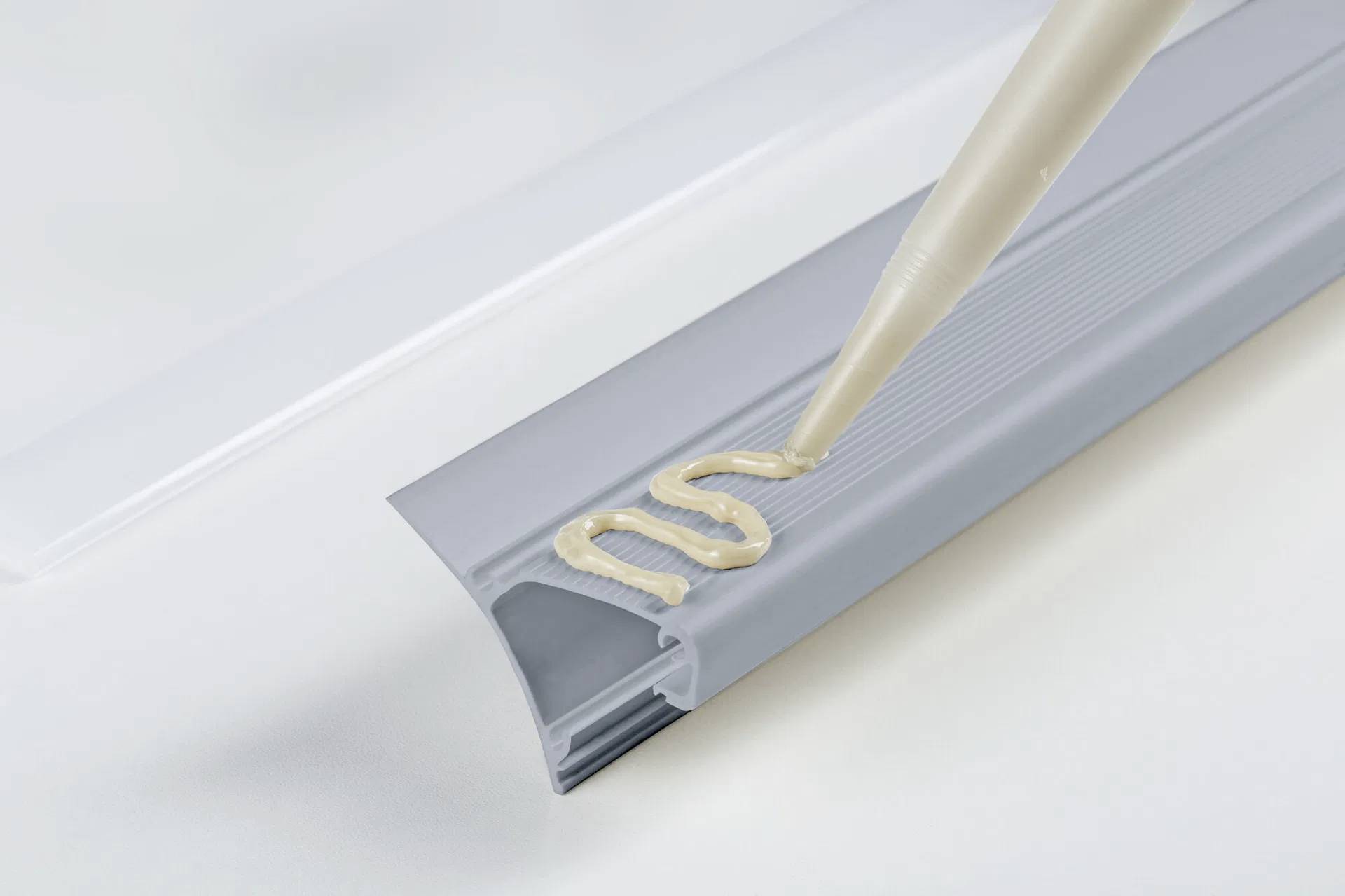 Eine Hand befestigt einen LED-Streifen in einem Aluminiumprofil. Der LED-Streifen wird in die Schiene gedrückt, um Beleuchtung zu integrieren.