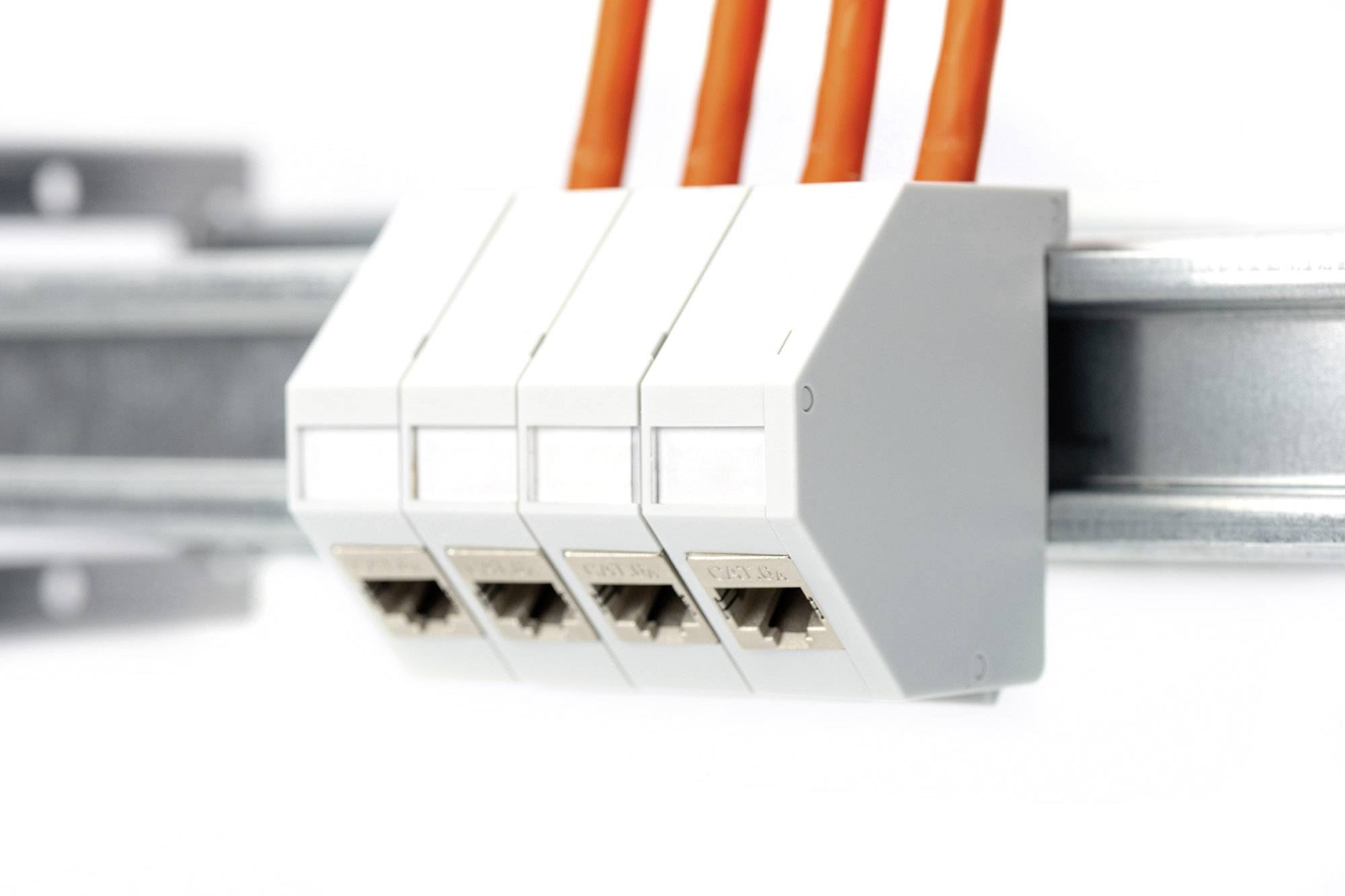 Vier orange Kabel sind an Ethernet-Buchsen in einer grauen Halterung auf einer Metallschiene angeschlossen.