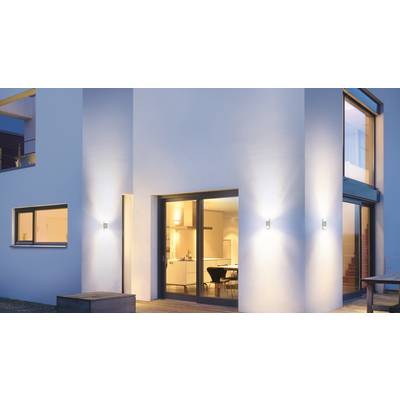 Modernes zweistöckiges Haus mit großen Fenstern und Außenbeleuchtung, die warme, einladende Atmosphäre schaffen.