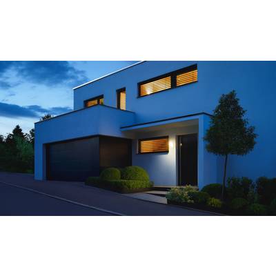 Modernes zweistöckiges Haus bei Dämmerung, beleuchtete Fenster, gepflegter Garten, Garage links.