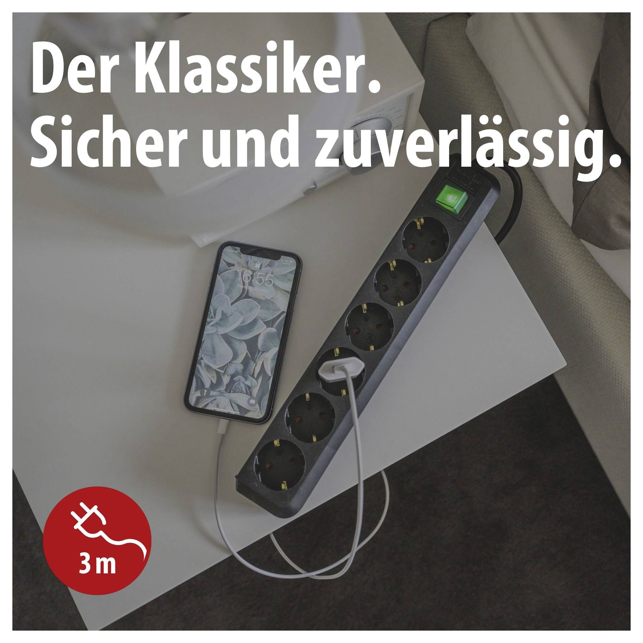 Werbung für Steckdosenleiste mit langem Kabel: Text 'Der Klassiker. Sicher und zuverlässig.'; Handy lädt neben der Leiste.