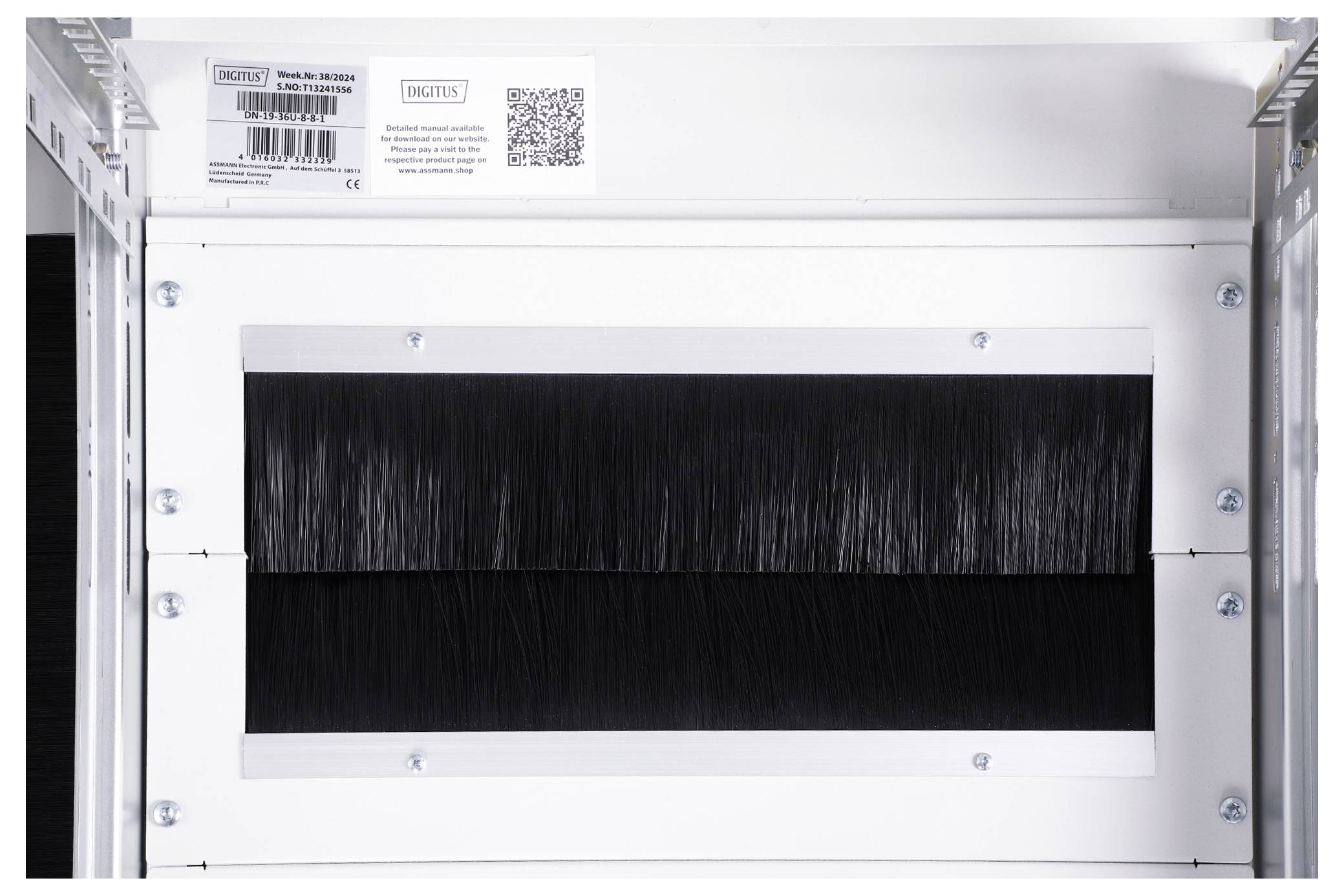 Ein weißer Rahmen mit schwarzer Bürstenleiste zur Kabelführung in einem Serverraum. Oben befindet sich ein Barcode und QR-Code.