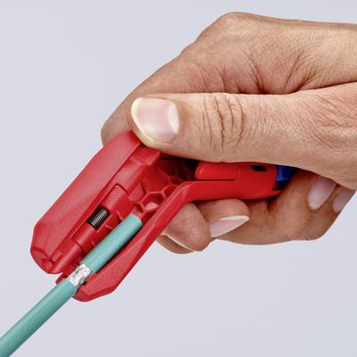 Hand hält ein Abisolierwerkzeug, das ein rotes Kabel abschneidet. Das Bild zeigt den Abisolierprozess in Aktion.