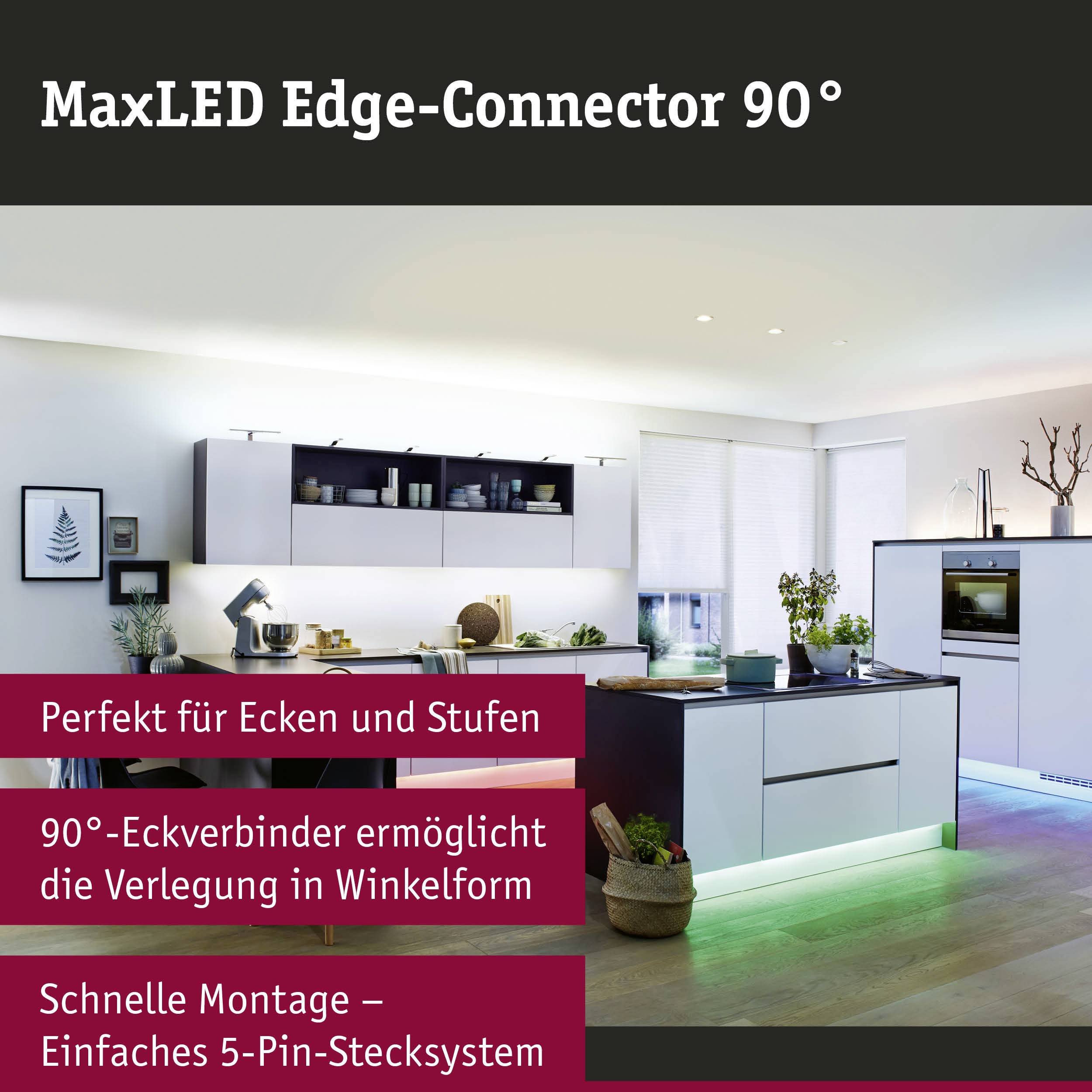 Die Küche ist modern eingerichtet mit weißen Schränken und einer zentralen Insel. Ein LED-Lichtband beleuchtet die Stufen.