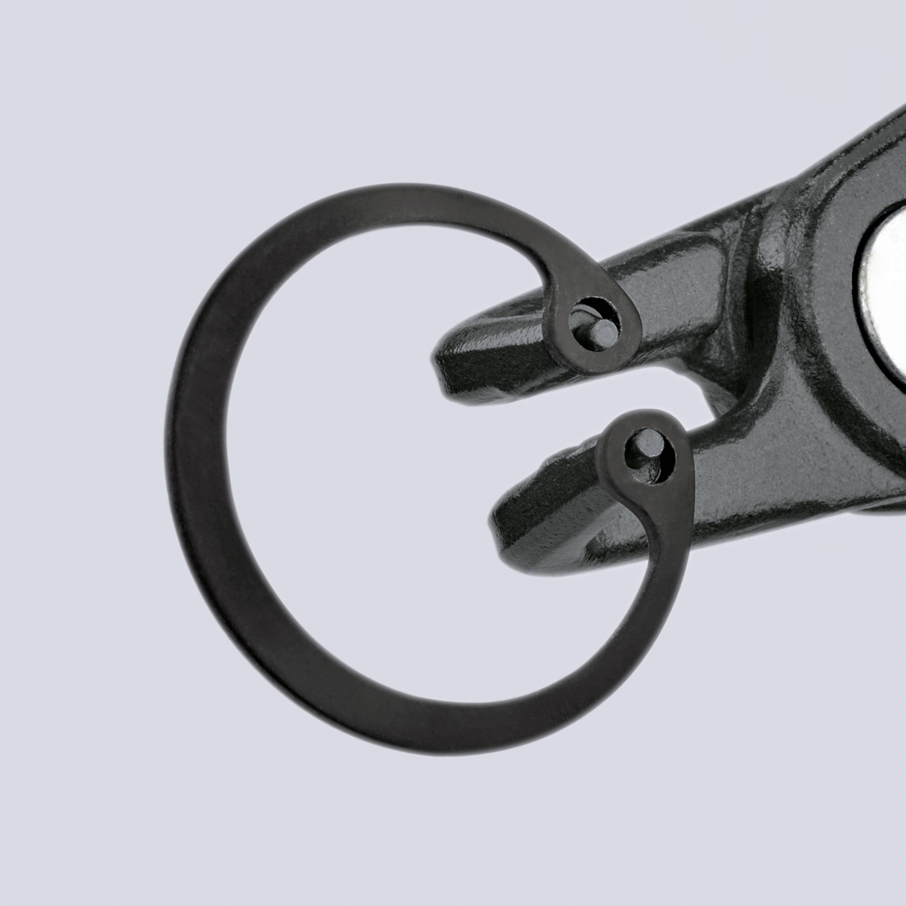 Ein Sicherungsring und eine Zange zum Einbau oder Entfernen solcher Ringe, dargestellt vor einem einfarbigen Hintergrund.