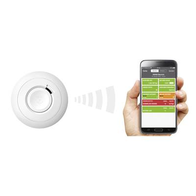Ein Rauchmelder sendet ein Signal an ein Smartphone, das eine App mit Statusanzeigen für verschiedene Sensoren zeigt.