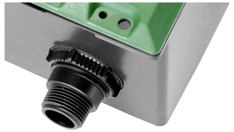 Eine Nahaufnahme der Ecke einer Plastikbox mit einem schwarzen Kabelverschraubung, die zum Sichern und Abdichten von Kabeln in elektronischen Gehäusen verwendet wird.