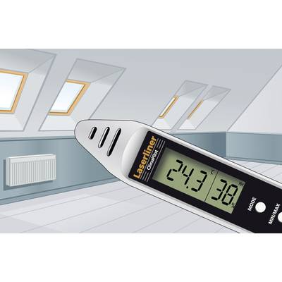 Ein Infrarot-Temperaturmessgerät zeigt '24,3 °C' an. Hintergrund: Dachboden mit schrägen Dachfenstern und Heizkörper.