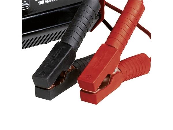 Rote und schwarze Starthilfekabel mit Klemmen, die an eine Batterie angeschlossen sind, zeigen die korrekte Polarität für die Starthilfe.