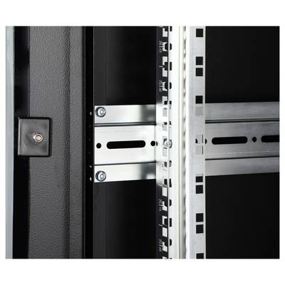Inneres eines Serverracks mit Streben und Befestigungsleisten. Eine schwarze Taste oder Lampe ist links sichtbar.