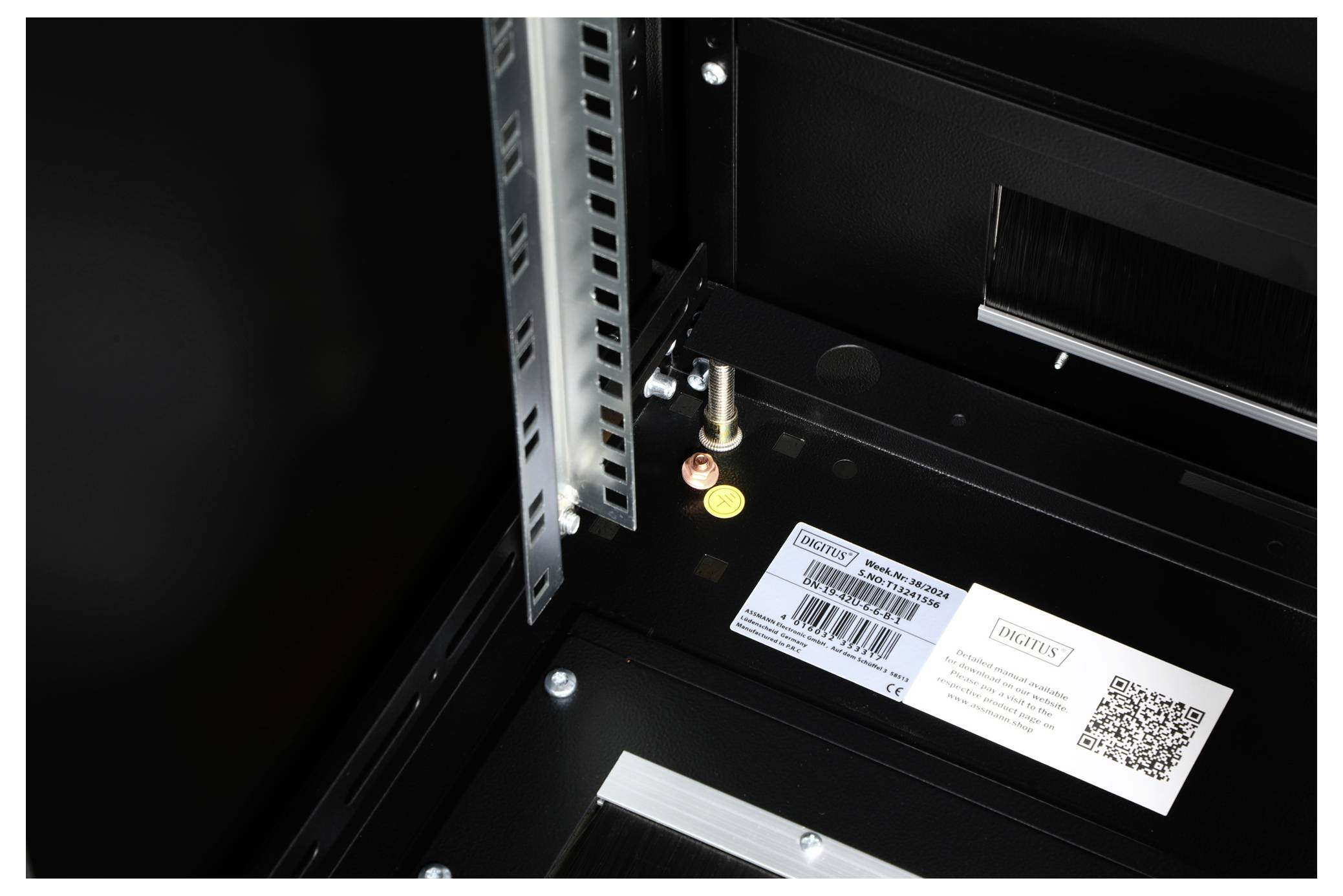 Einblick in einen offenen Schaltschrank; sichtbare Schrauben und ein Label mit QR-Code, ohne spezifische Informationen zu geben.