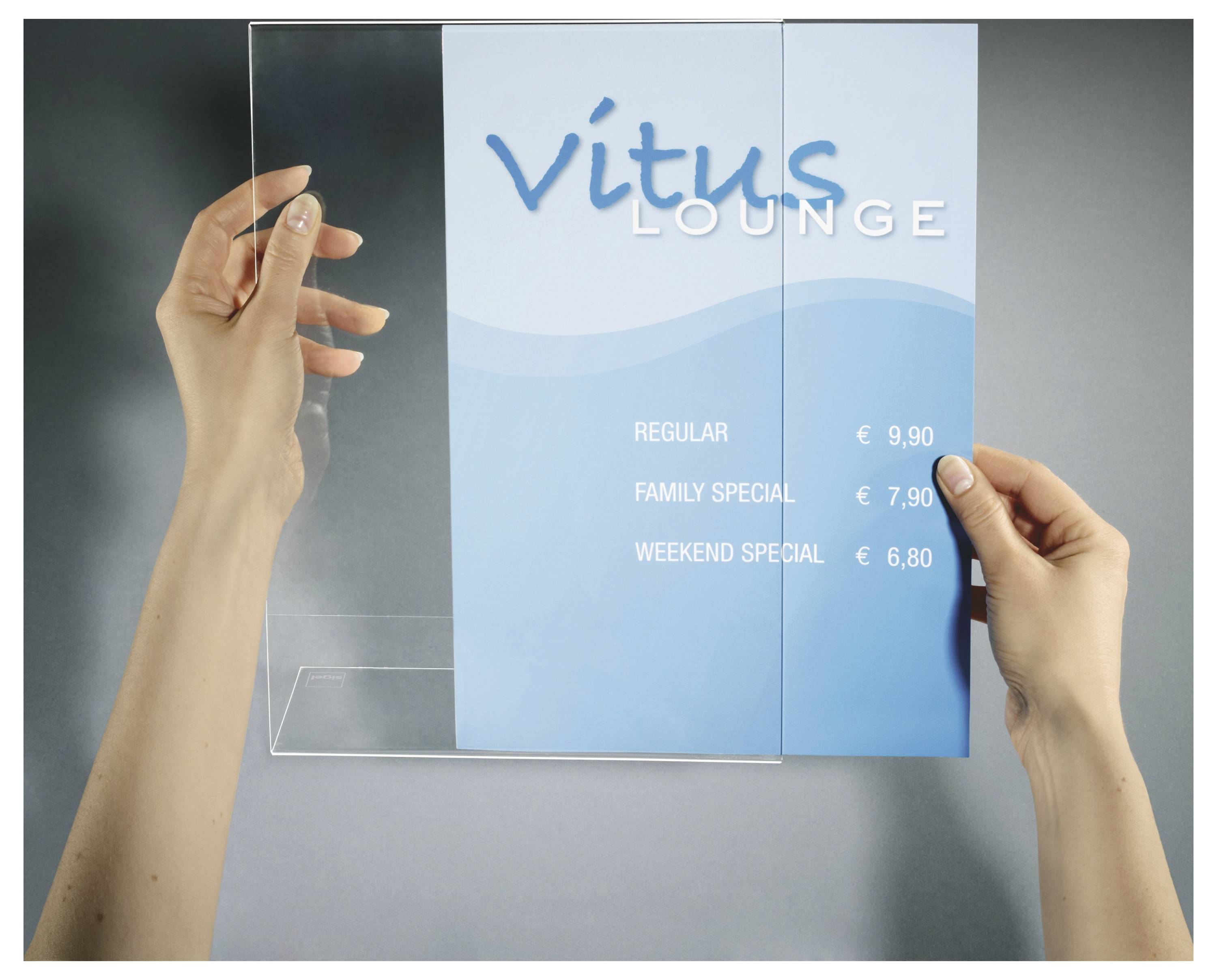Hände platzieren ein blaues 'Vitus Lounge'-Menü oder Flugblatt in einen klaren Wandauslagenschaukasten und zeigen reguläre Preise, Familienspezial- und Wochenendspezialpreise.