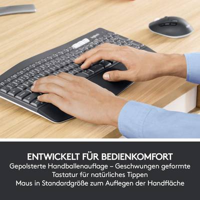 Person tippt auf ergonomisch geformter Tastatur mit gepolsterter Handballenauflage, Maus in der Nähe. Text betont Komfort beim Tippen.