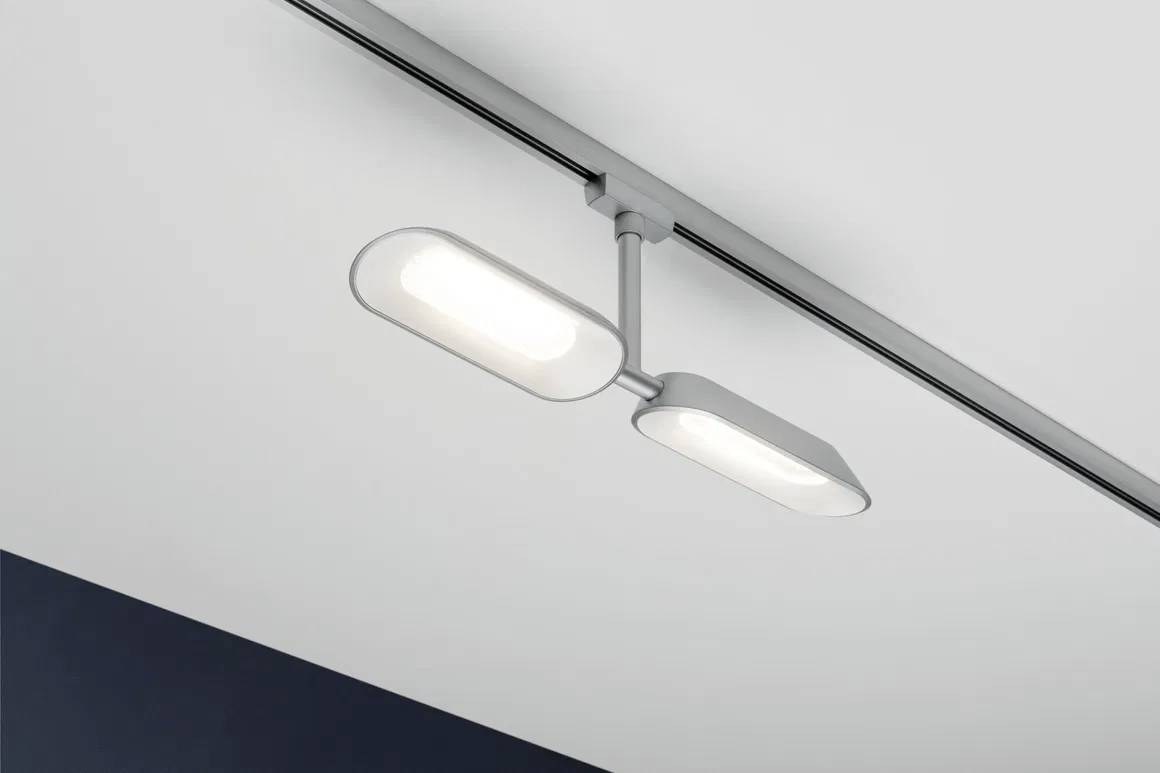 Deckenleuchte mit zwei rechteckigen, weißen LED-Lampen, montiert an einer Metallschiene in einem modernen, minimalistischen Raum.