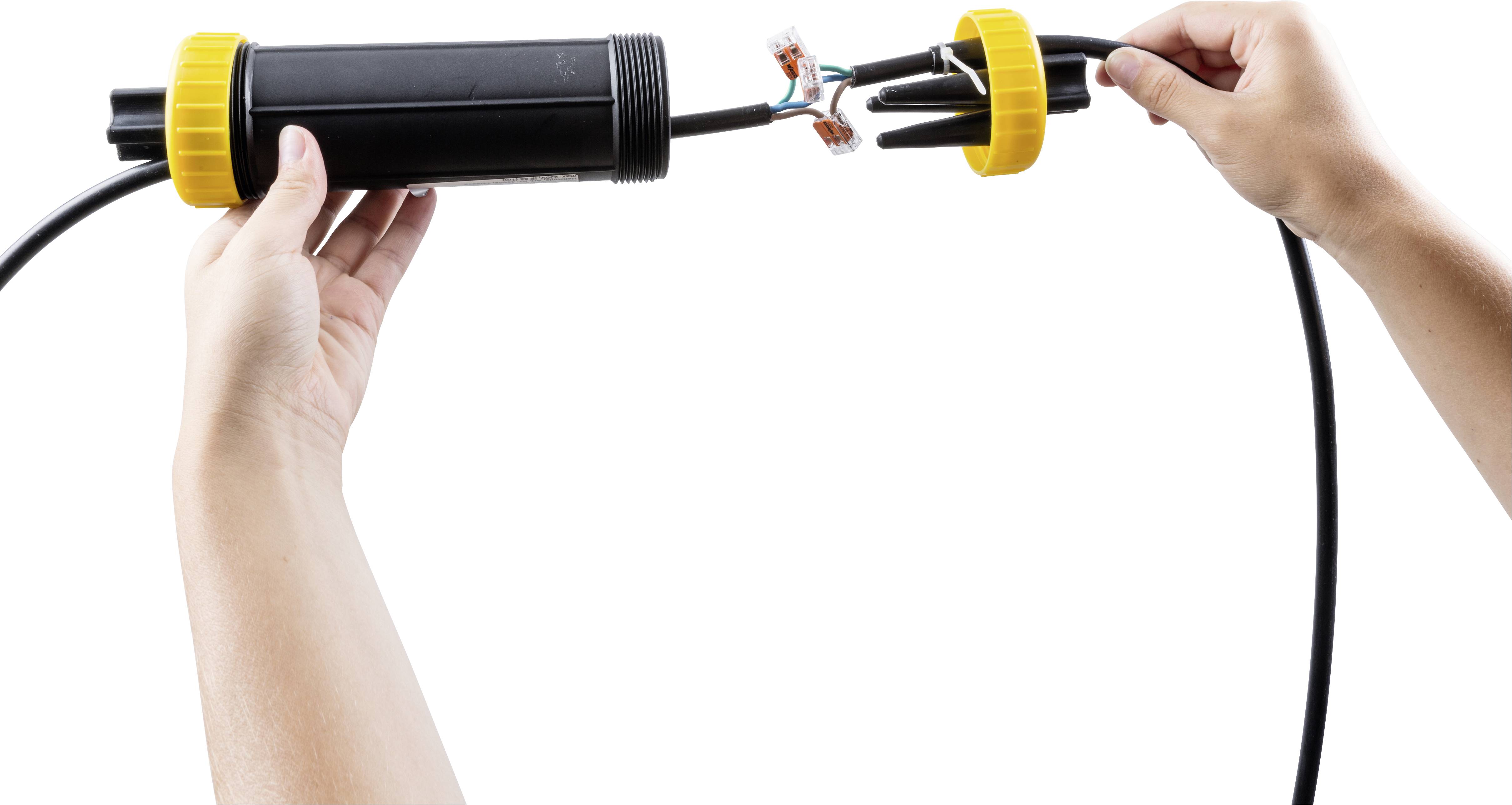 Eine Person verbindet zwei Teile eines Kabels mit einer Verbindungsdose. Die Enden der Kabel sind freigelegt und in der Dose platziert.