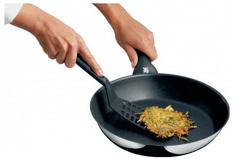 Zwei Hände halten eine schwarze Bratpfanne und einen Pfannenwender und wenden einen knusprigen Kartoffelpfannkuchen.