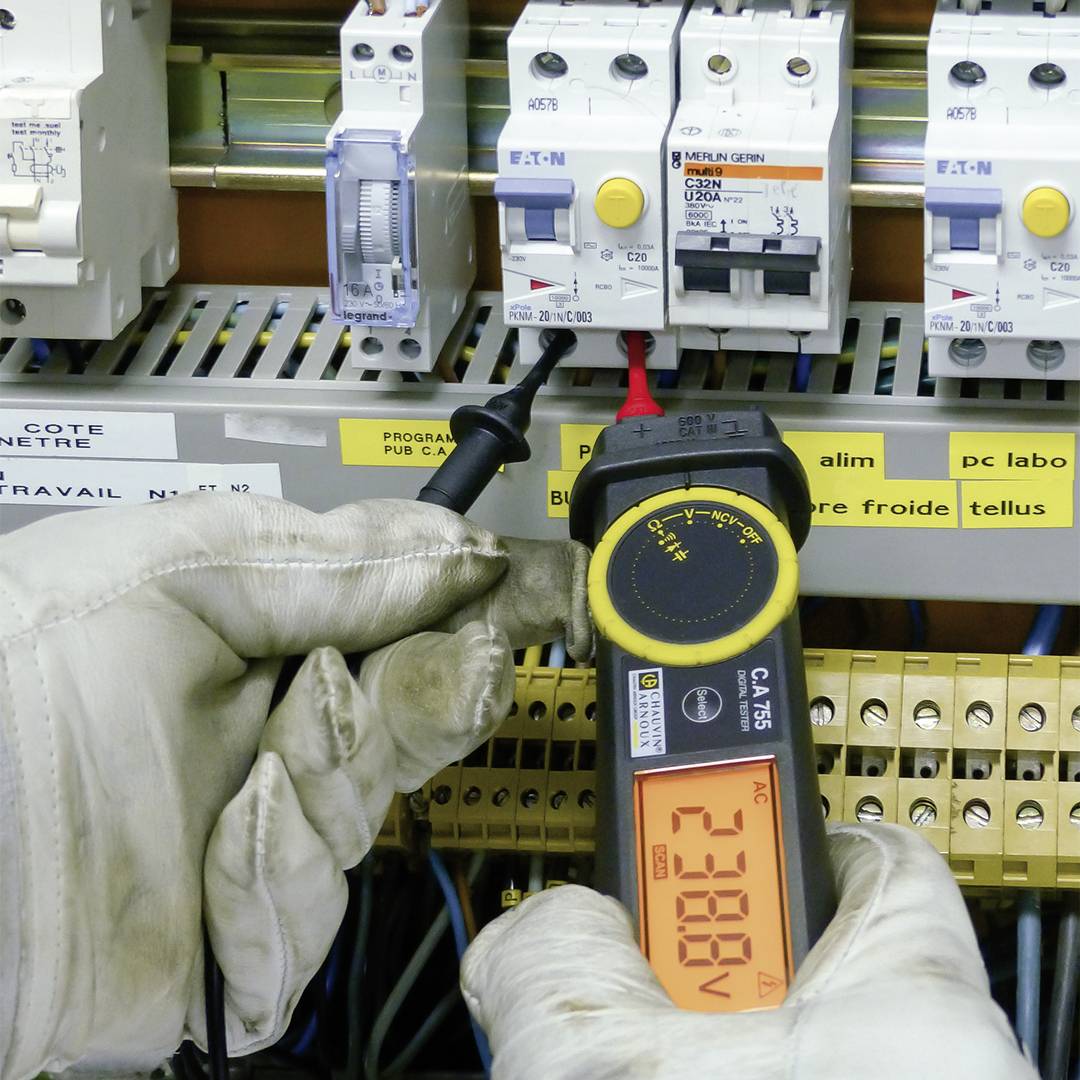 'Ein Elektriker verwendet ein Multimeter zur Spannungsmessung in einem elektrischen Schaltschrank. Die Anzeige zeigt 238,8 Volt.'