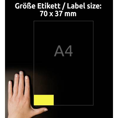Eine Hand zeigt auf ein gelbes Etikett im Format 70 x 37 mm auf einem A4-Blatt, vor schwarzem Hintergrund.